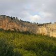 Vista general de los sectores (Castell d'Alaró) - Vistas desde la cerretera de ascenso poco antes de llegar al restaurante. En el tercio derecho de la pared se encuentra el sector sa Porta. El sector del Medio se puede ver en la imagen entorno a una cueva con forma de boca la la derecha de la zona central de la parez. En el último tercio de la imagen se pueden las chorreras que dan nombre al tercer sector.